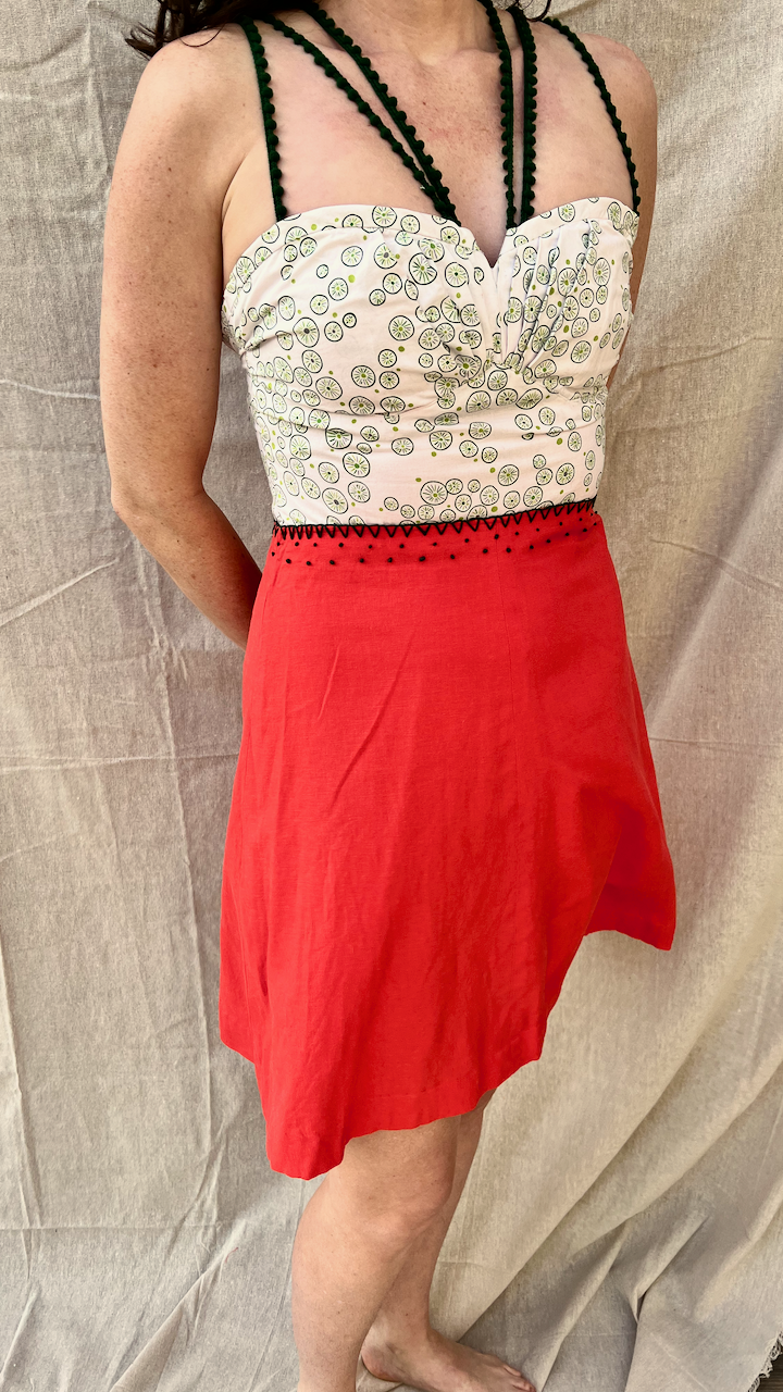 A strappy sundress with a green/white bodice and bright red skirt