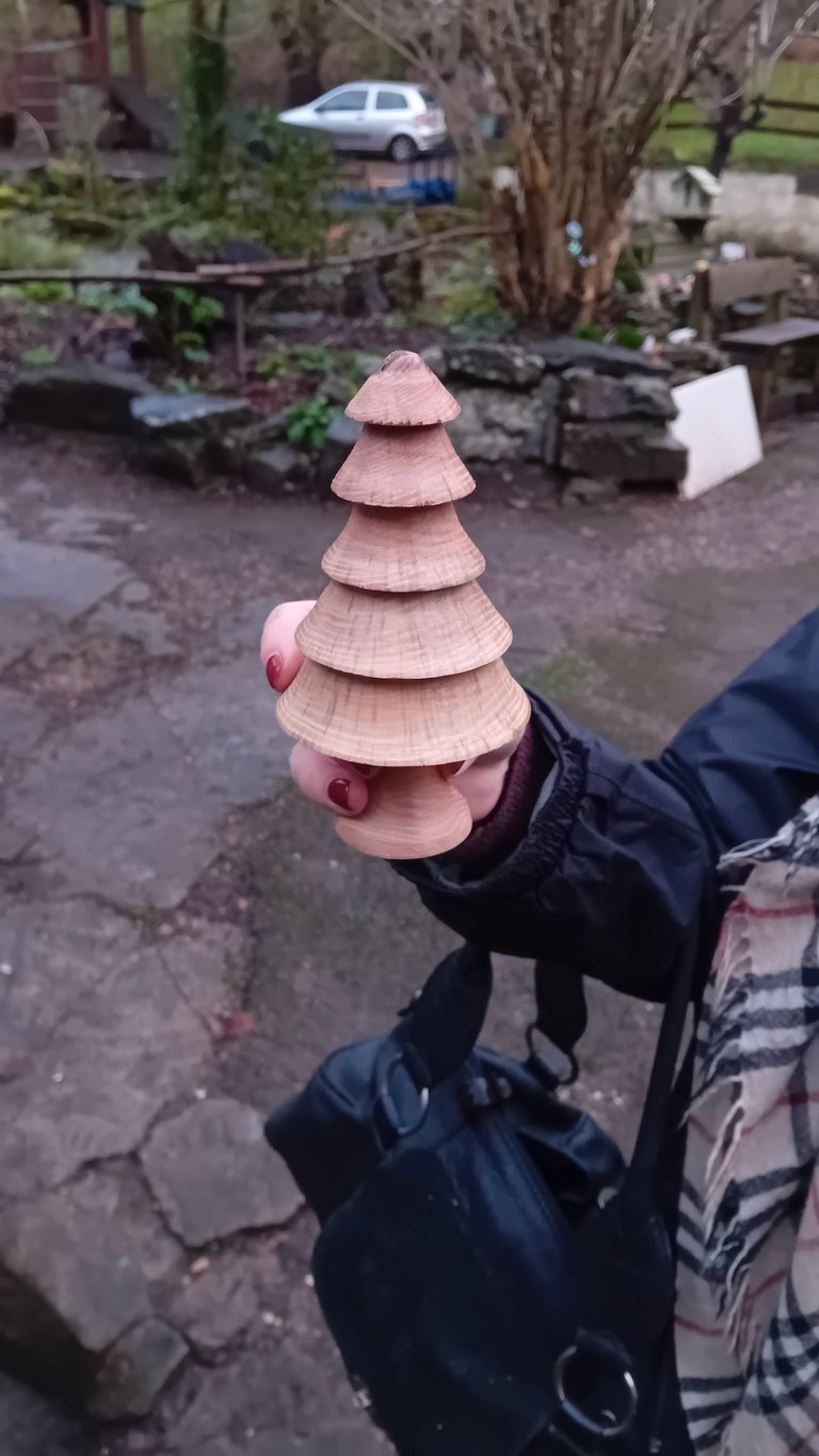 Hand holding a turned wooden fir tree