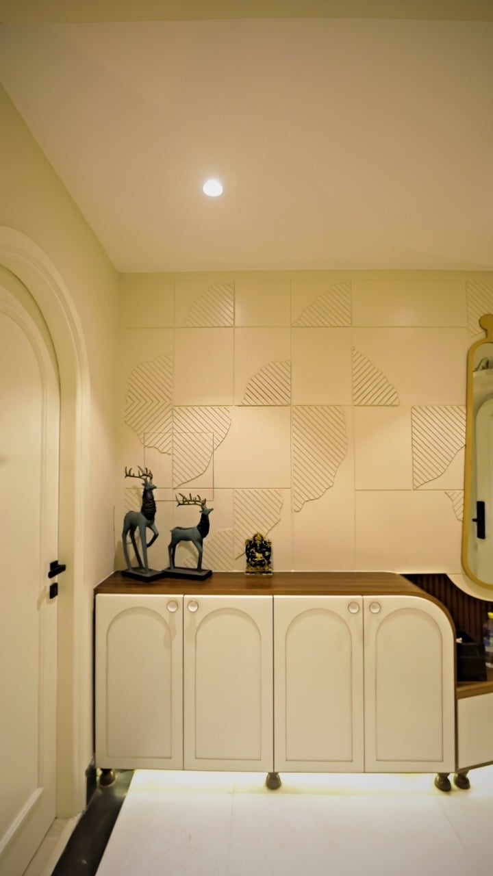 Modern home entryway featuring a white storage cabinet with deer figurines and textured wall paneling.