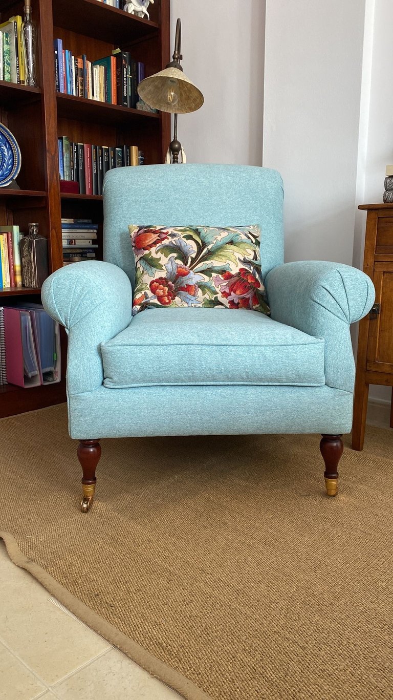 Sillón orejero tapizado en loneta azul celeste conservando patas con ruedas originales. Tenerife