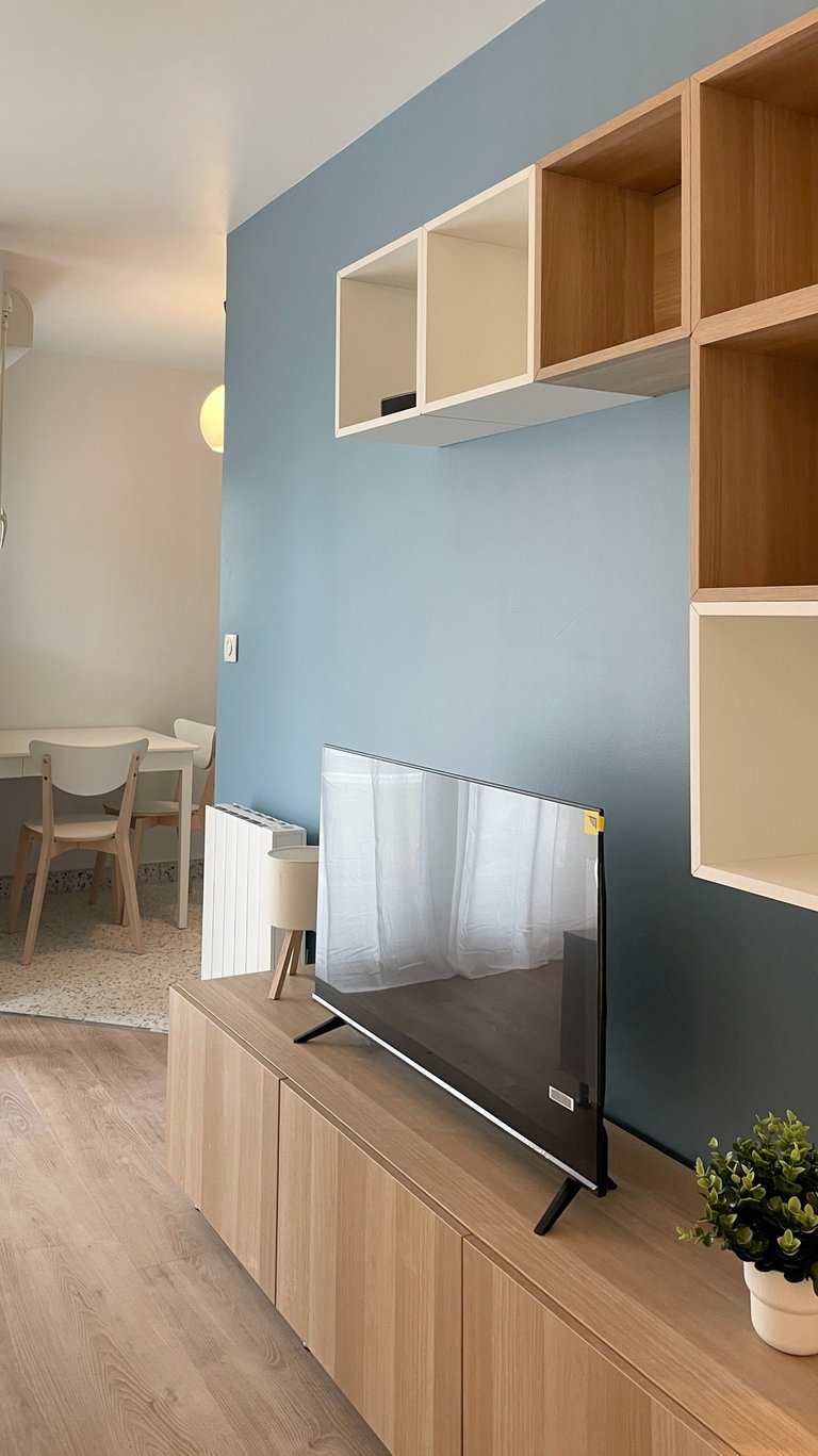 a flat screen tv sitting on a wooden entertainment center