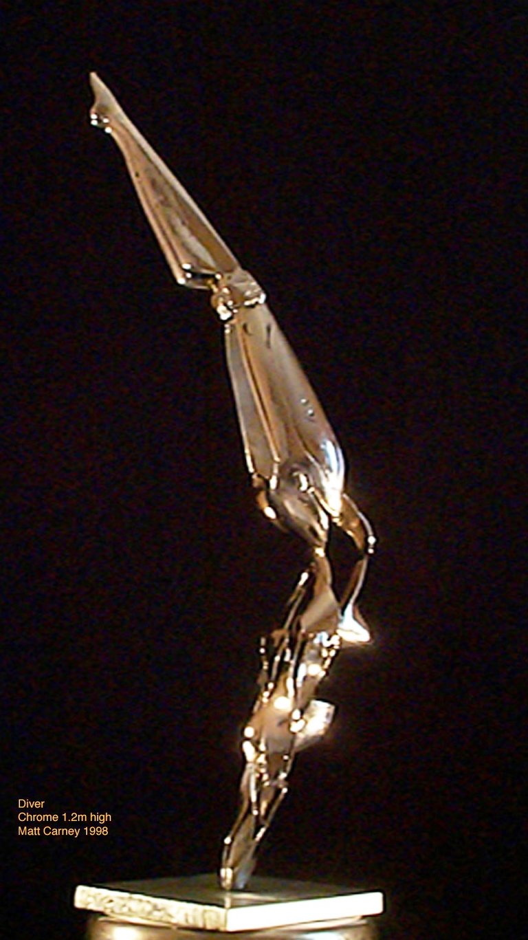 a chrome plated steel sculpture of a futuristic woman diving into a pedestal
