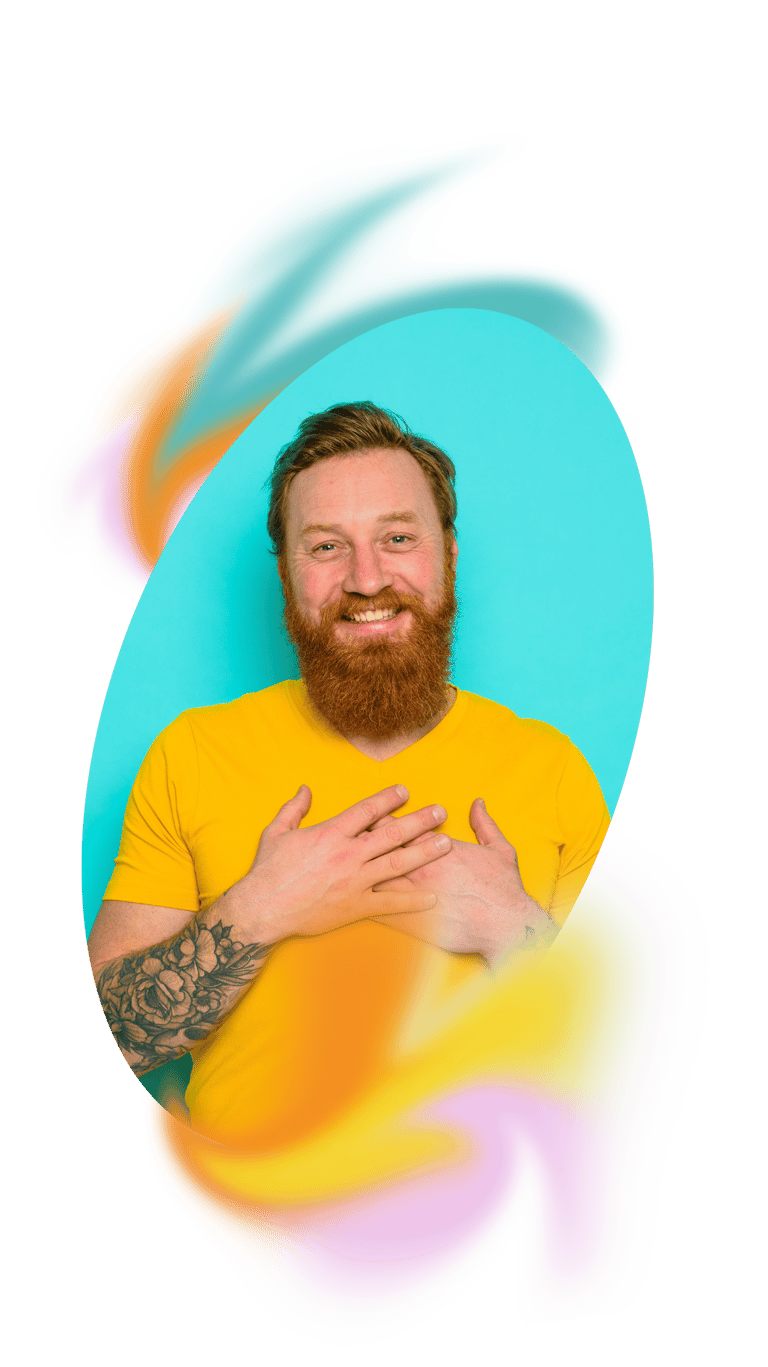 a white man with a beard holding his hands to his heart and smiling