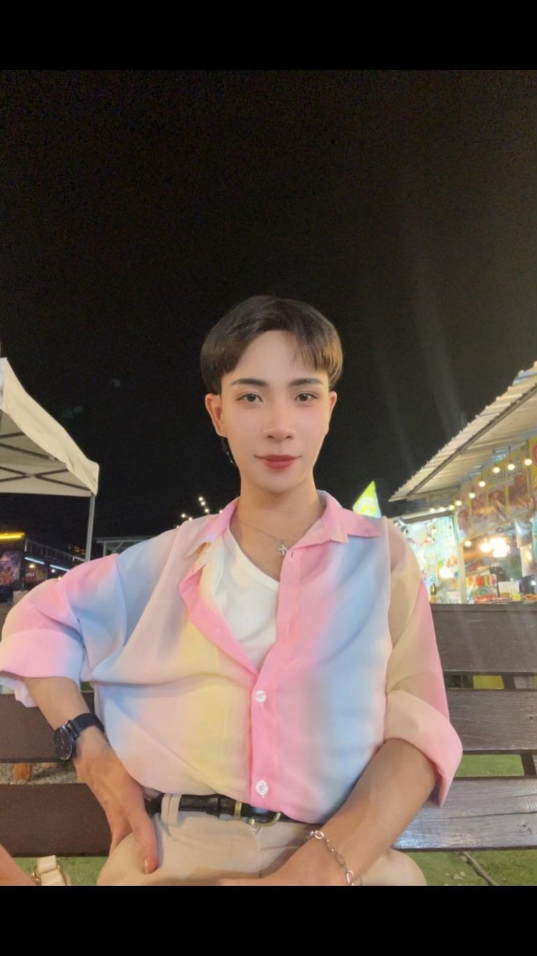 Experienced home massage therapist in Pattaya with a friendly and welcoming appearance, photographed in a night market