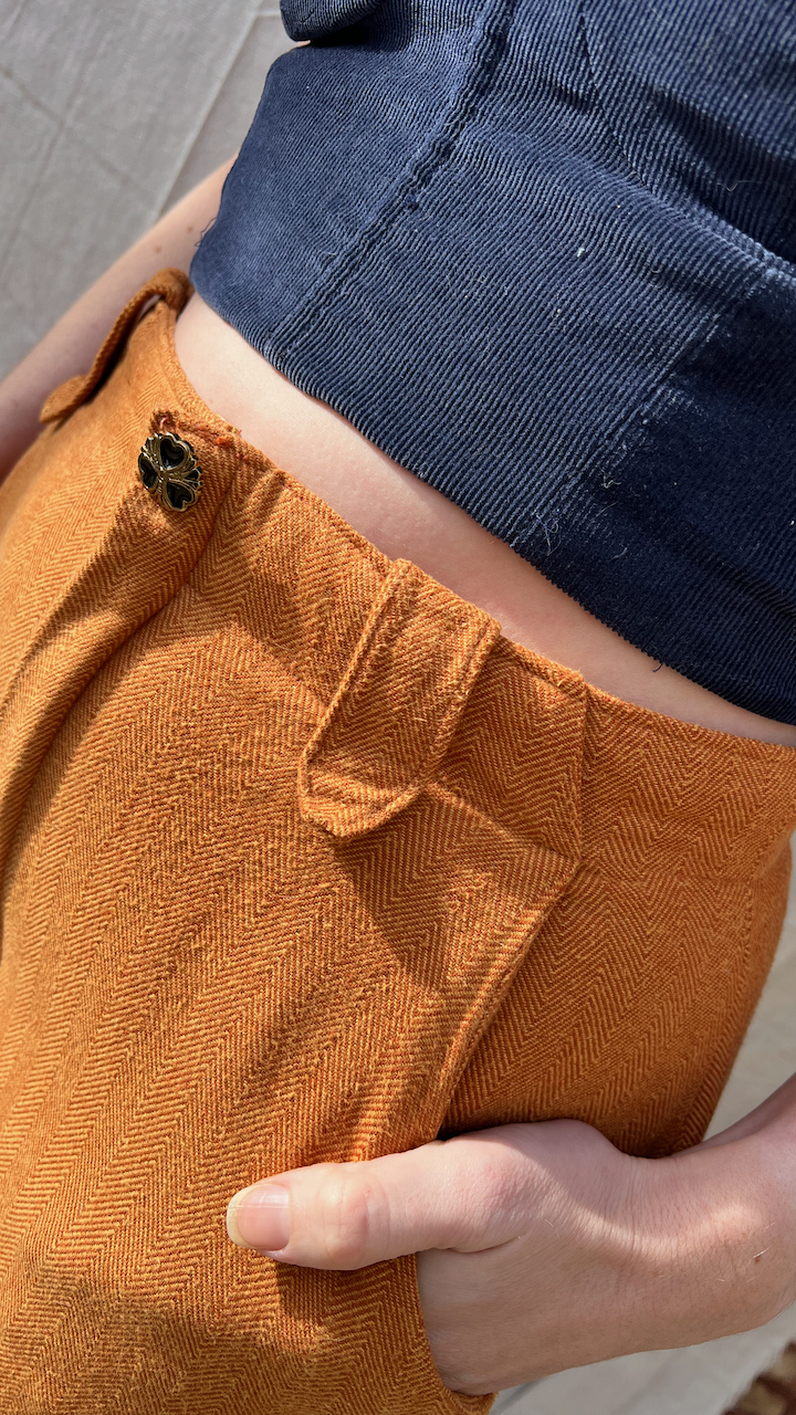 Waist detail of a navy corduroy bustier and honey brown flannel pants