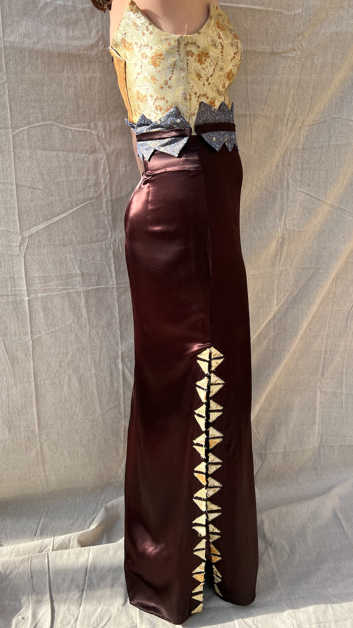 A woman in a gold brocade and satin evening gown