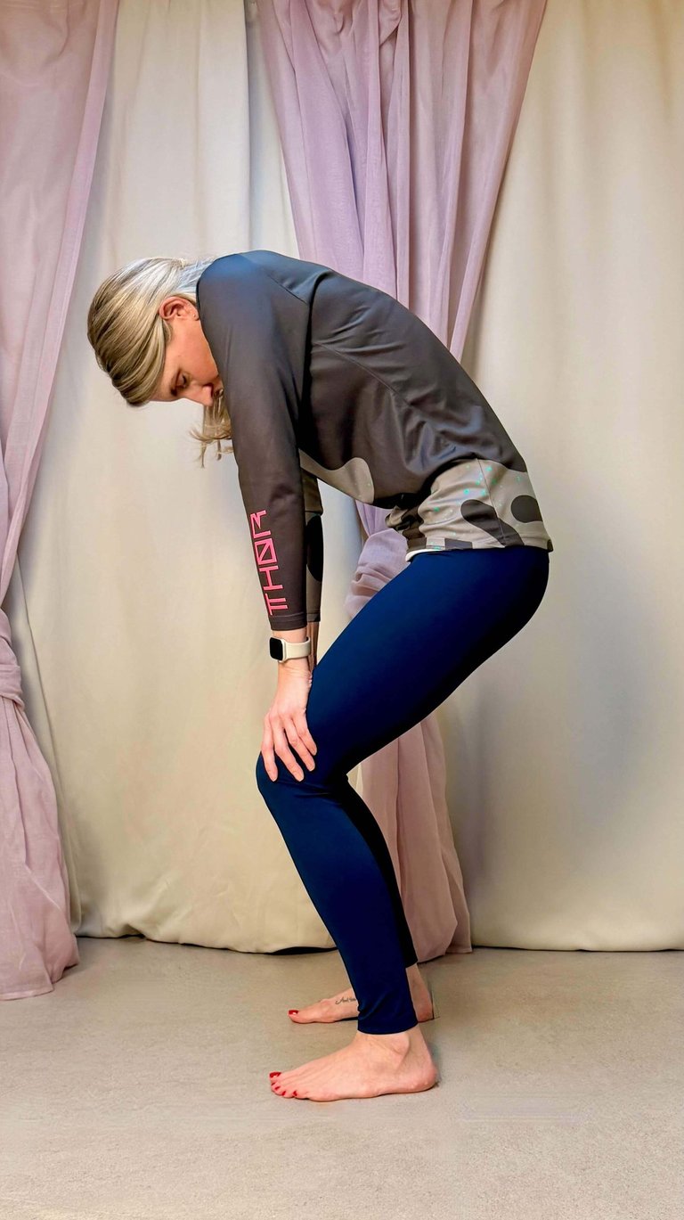 Yogalehrerin Anja mit Katzenbuckel im Stehen zur Mobilisierung des Rückens
