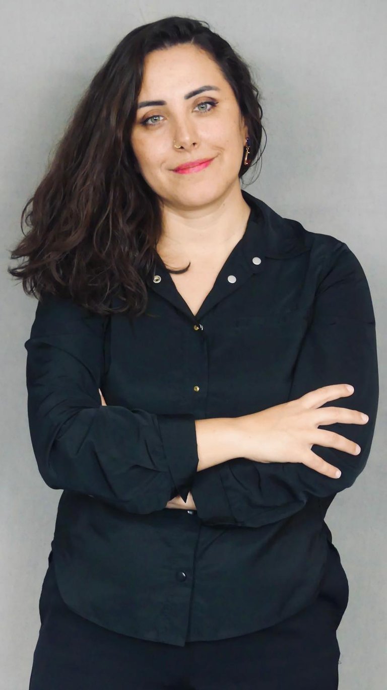 Porträt der Psychotherapeutin Linda Acikalin mit verschränkten Armen, selbstbewusst lächelnd.