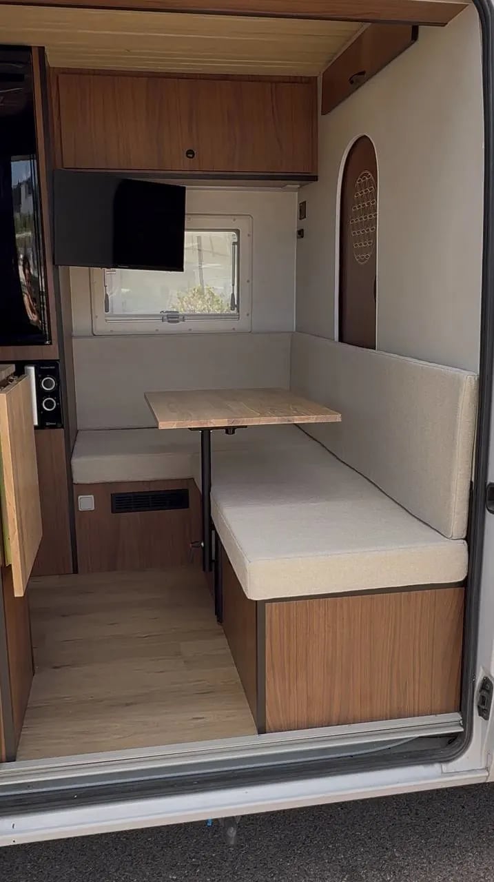 Una furgoneta con un sofá y una mesa en la parte trasera.