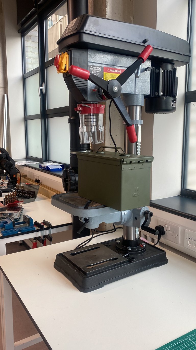 Pillar drill creates holes in an ammunition box