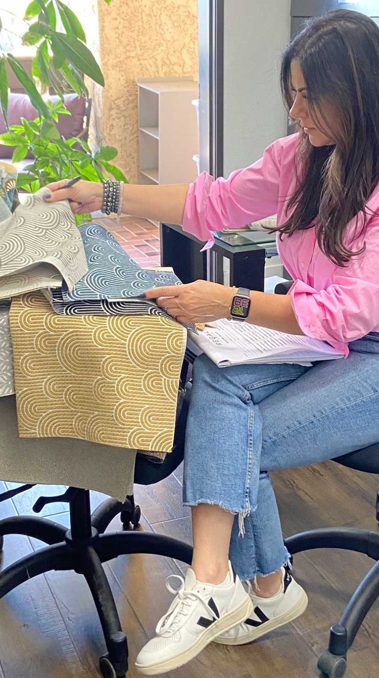 Sigal, founder of Solo Home Decor, selects fabrics while designing custom furniture.