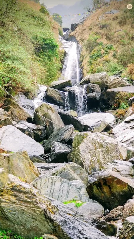 Bhagsunag Waterfall cascading through rocky boulders near McLeod Ganj, Himachal Pradesh.
