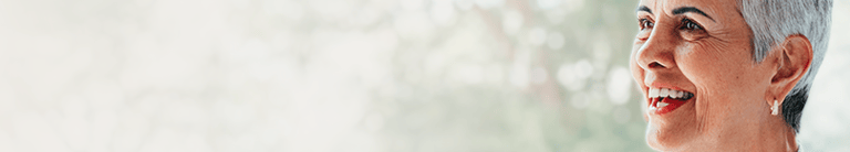 senhora sorrindo, utilizando aparelhos auditiovos