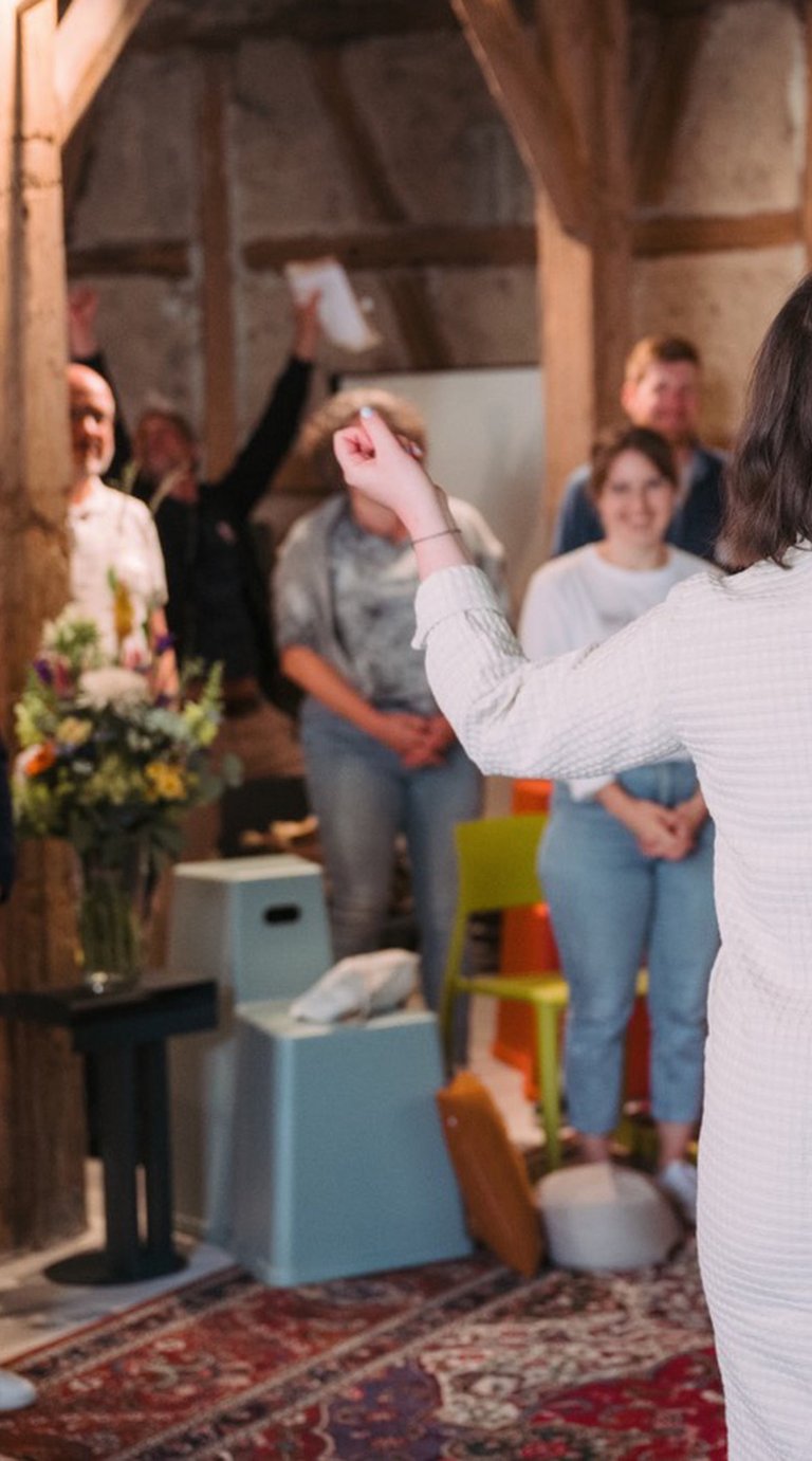 Menschen im Kreis bei einem Workshop des Loop Fellow Forums, verbunden im Gespräch.