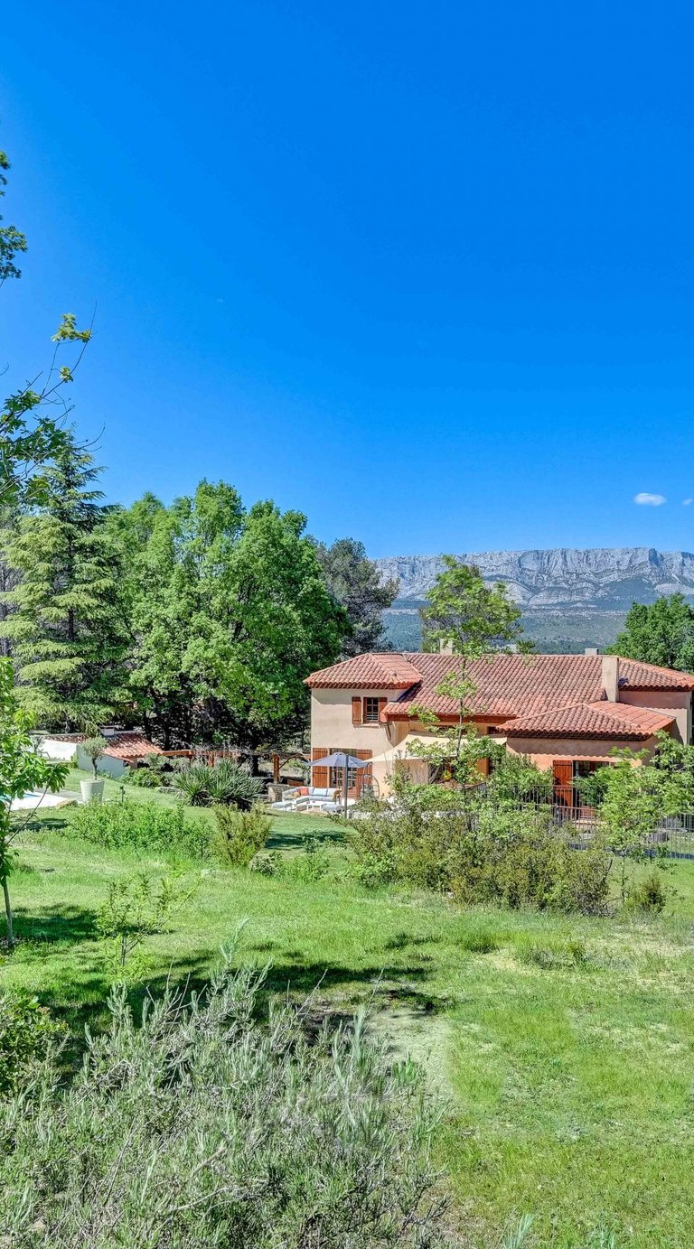 a house with a pool and a pool in the background