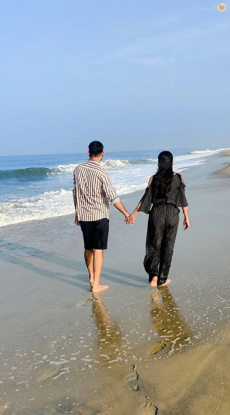 Couple walking hand in hand on Alleppey Beach in Kerala during sunset, enjoying the sea breeze and peaceful shoreline views.