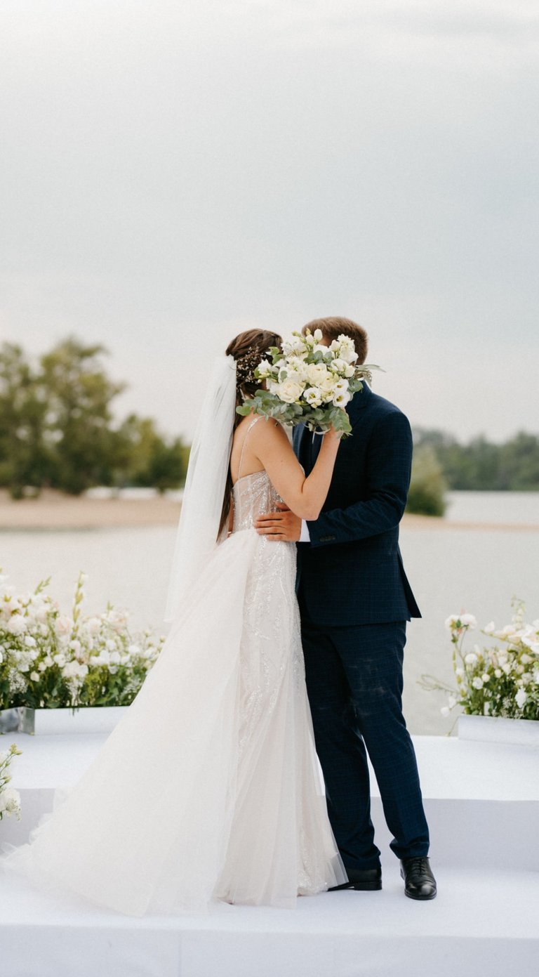Bride and groom kiss at outdoor ceremony, bouquet raised—filmed by Imack Wedding Films, Glasgow.