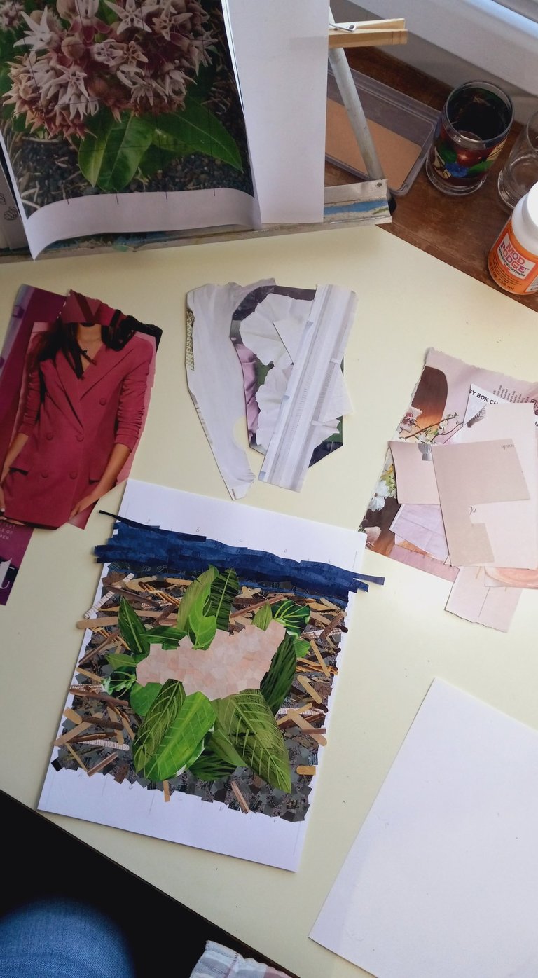Handmade paper collage on a desk with green leaf cutouts and fashion magazine scraps.