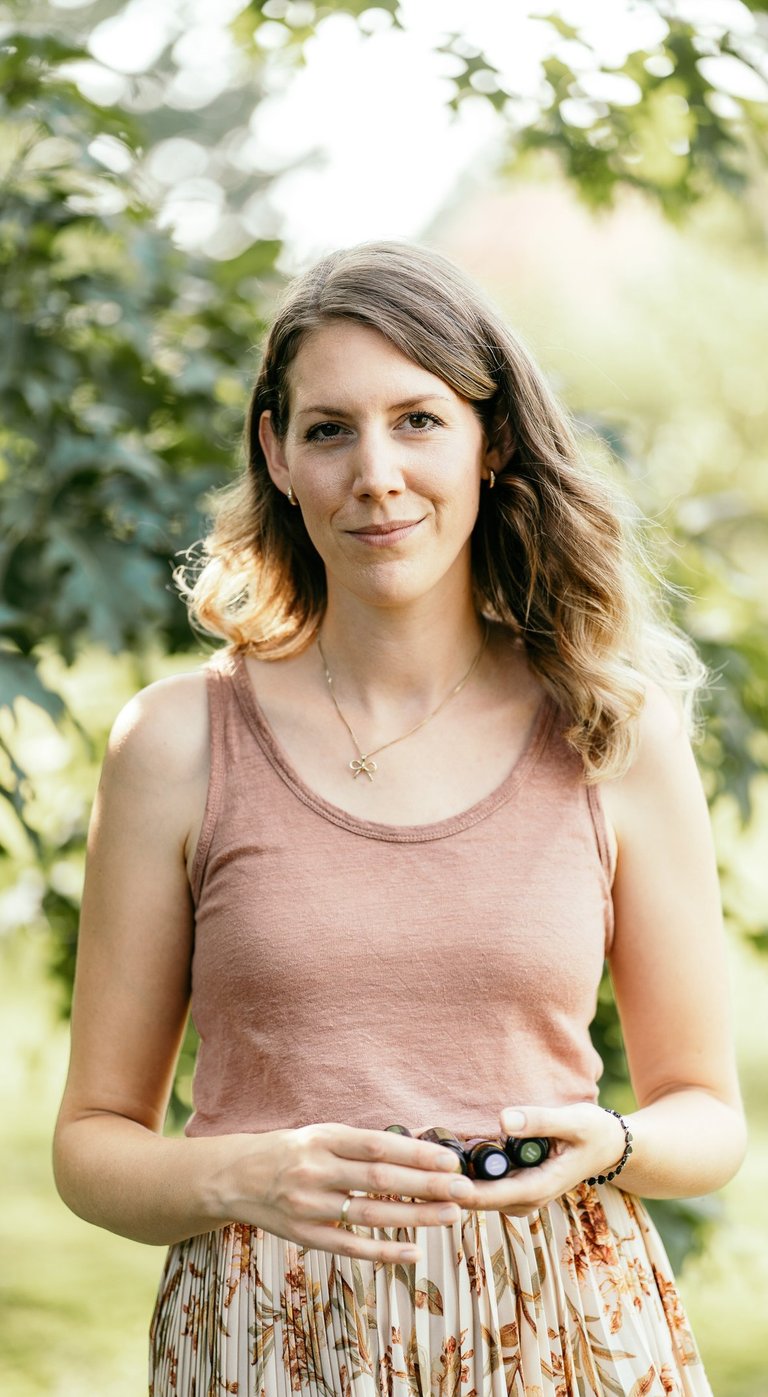 Marie, dōTERRA Wellnessbotschafterin, hält ätherisches Öl zur persönlichen Beratung