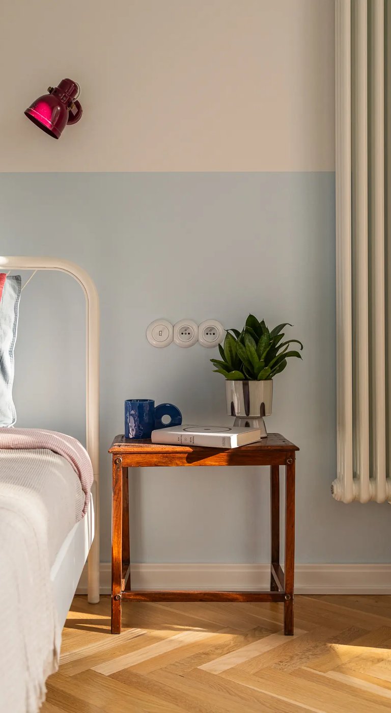 Stylizacja wnętrza: stolik vintage i błękitna lamperia w sypialni.