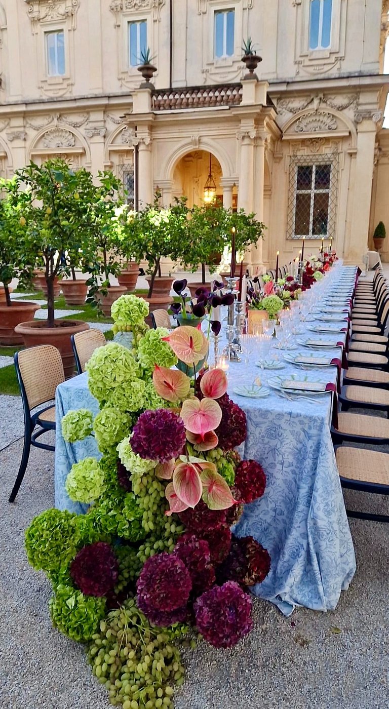 Elegant outdoor wedding dinner table with floral centrepiece, Rome.