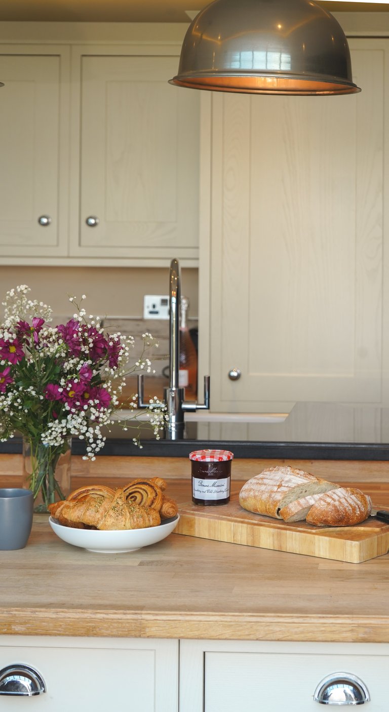 a table with bread and a vase of flowers
