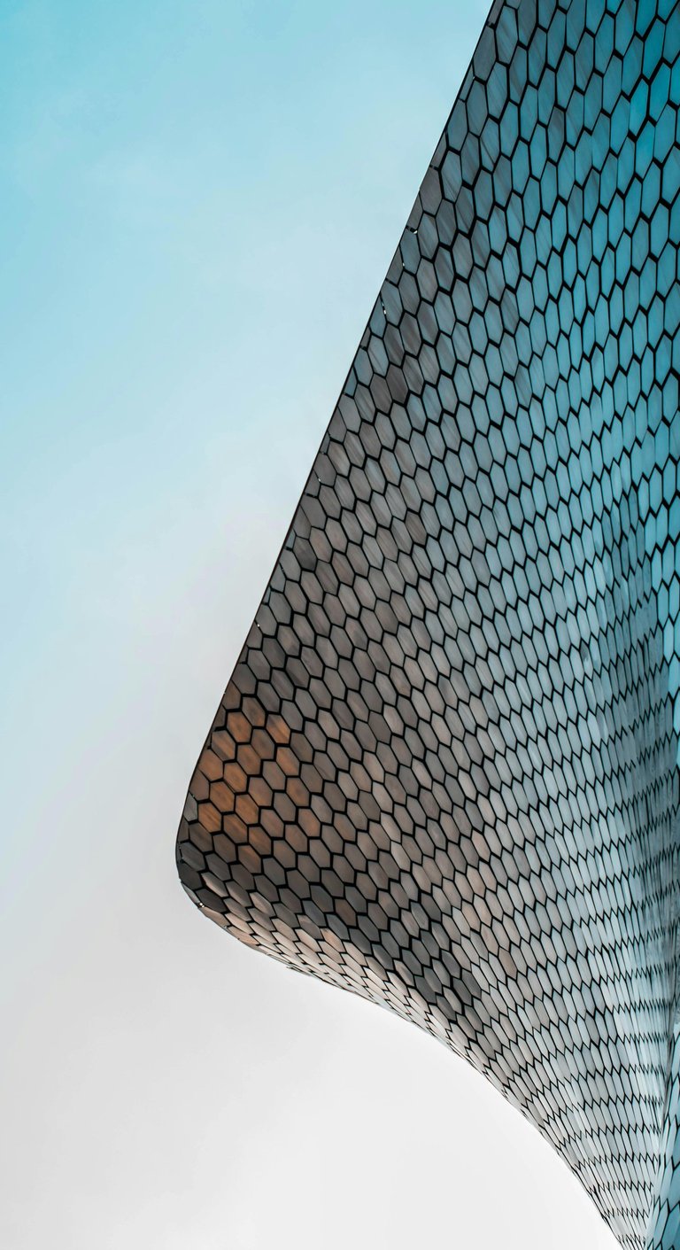 Low-angle view of the modern Soumaya Museum architecture with its reflective silver hexagonal tiles.