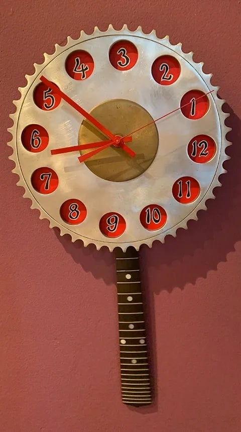 Clock made from aluminum gear with pendulum made from mandolin fretboard.