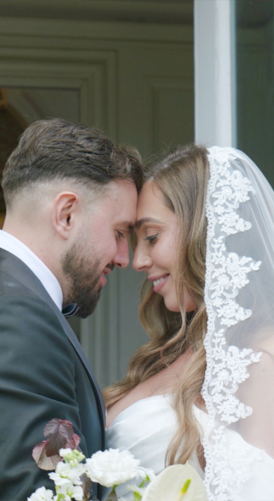 A bride and groom gaze lovingly at each other, surrounded by a soft, romantic atmosphere.