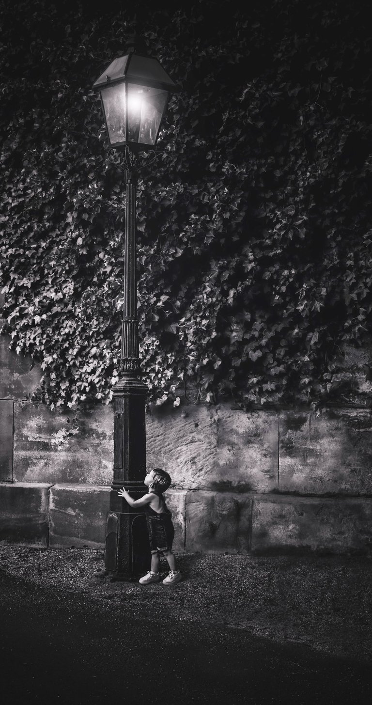 Fine art photograph a little boy looking at a lamp post 