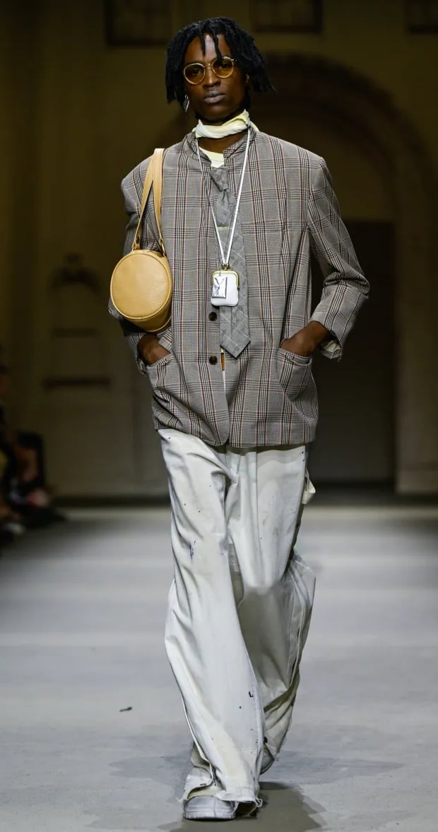 Model in oversized checked blazer and wide-leg trousers at Coach Spring/Summer 2026 runway show.