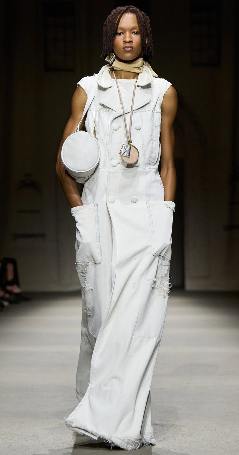 White sleeveless coat dress with round bag on Coach SS26 runway.