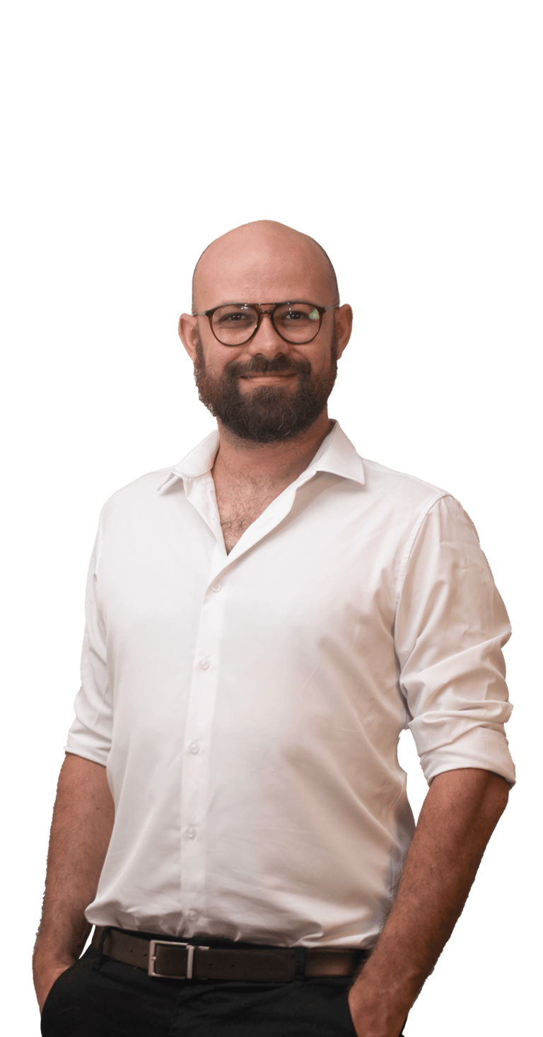 a man with a beard and glasses standing in front of a green background