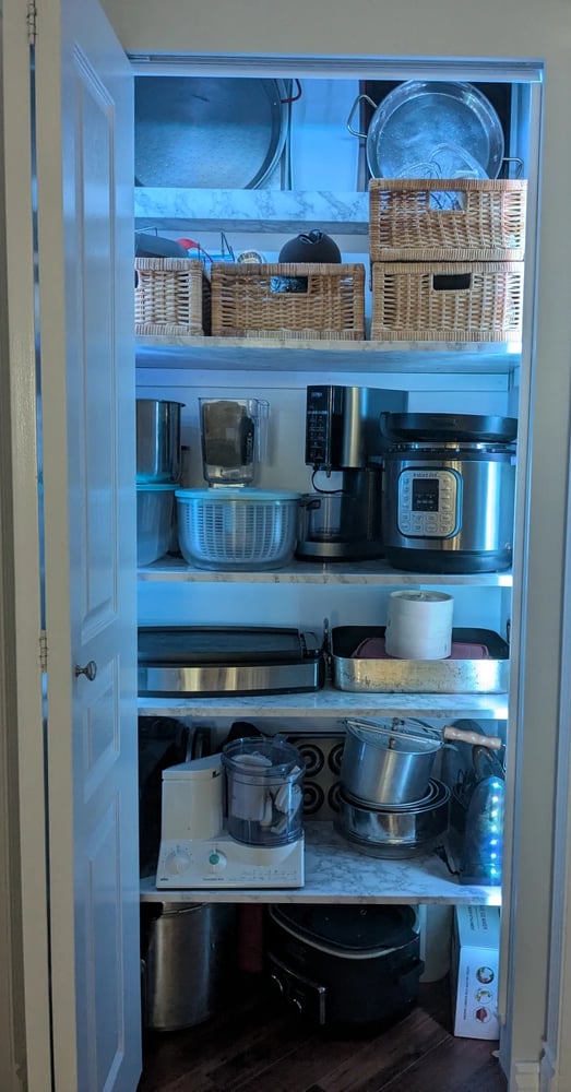 Kitchenware closet, with strip lighting to illuminate deep shelves