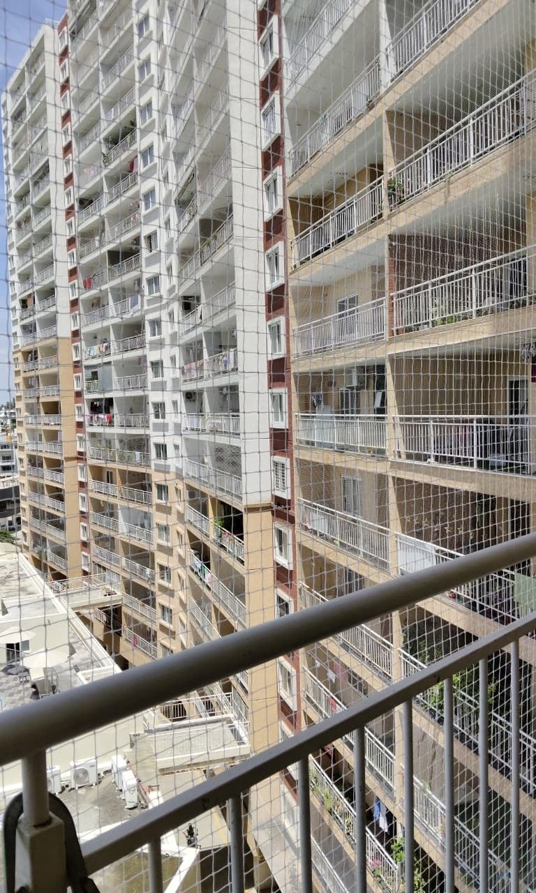 a balcony with a view of a pool and a fenced in area
