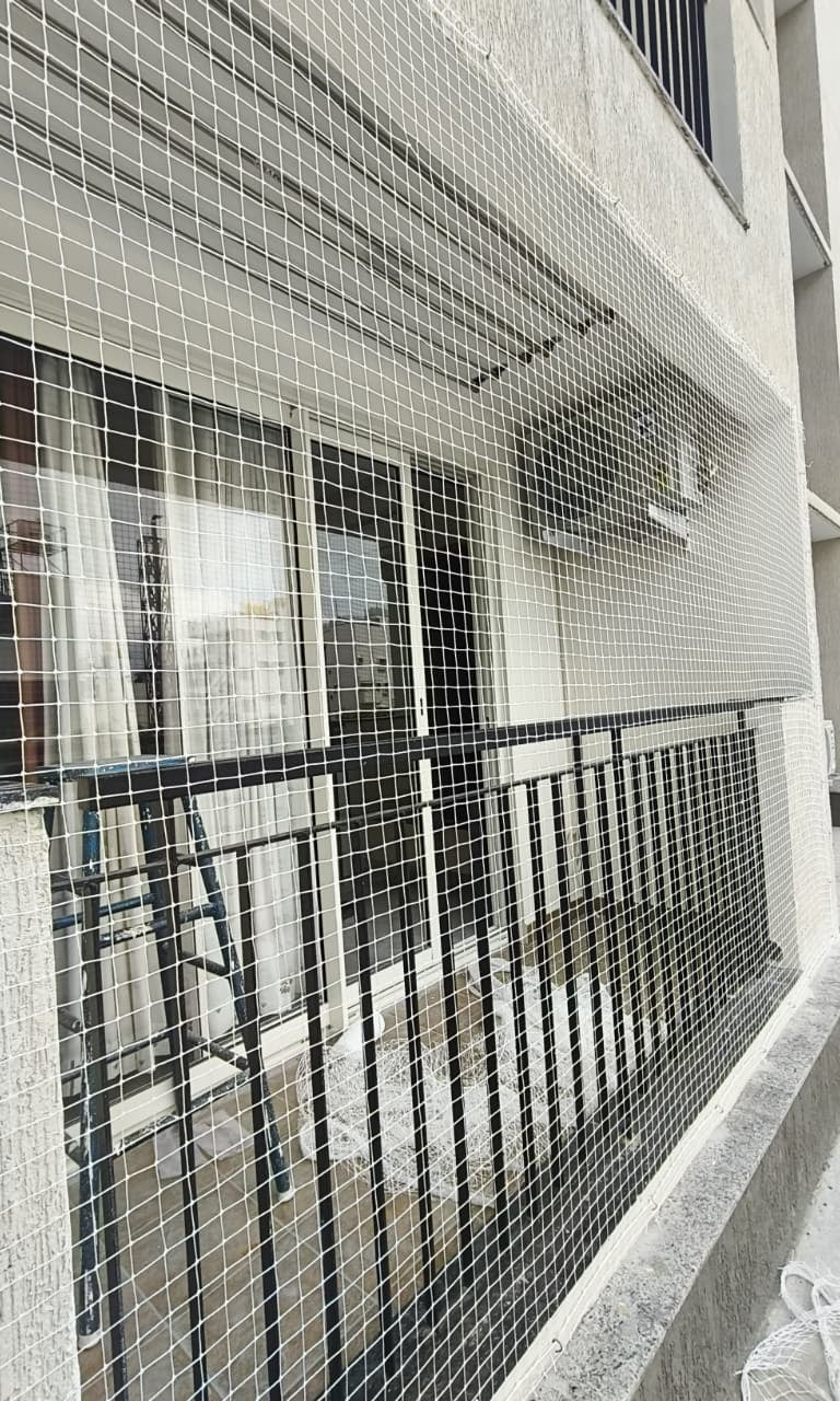 a building with a Balcony nets installed in area with a fenced in area