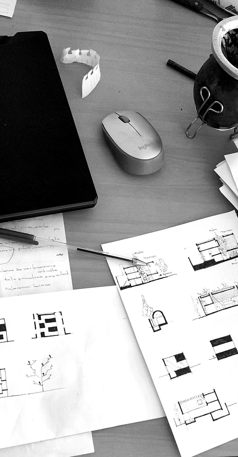 Foto de escritorio con dibujos y notebook. Arquitecto Pablo Suarez