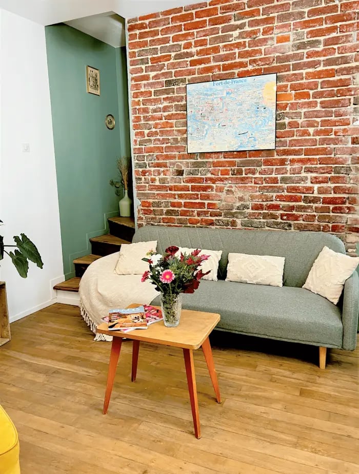 Espace détente de la Maison des Voyageurs, style industriel avec briques apparentes et table vintage