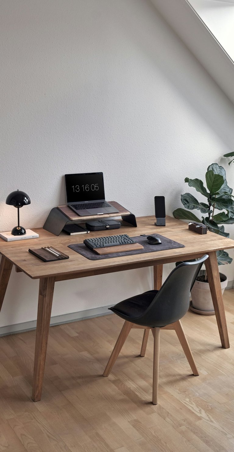 Minimal modern workspace with wooden desk, laptop and natural daylight
