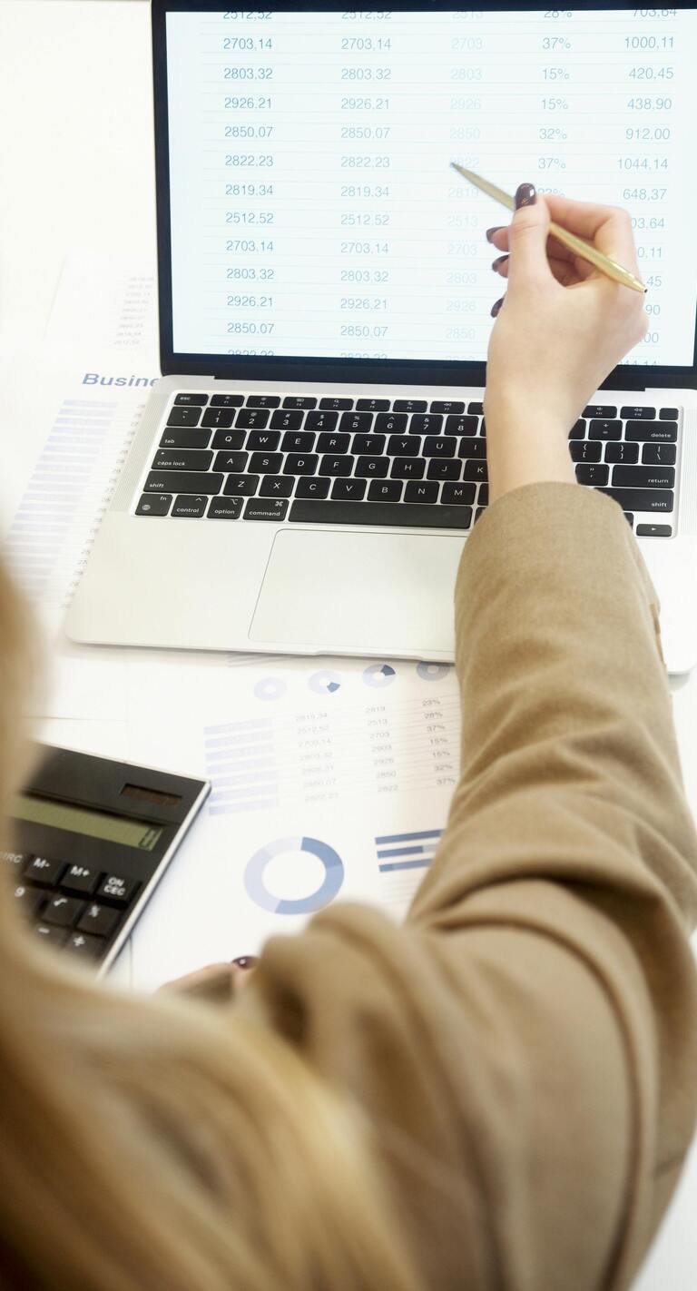 photographie d'une ordinateur portable et le bras d'une femme qui montre l'écran
