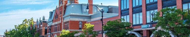 Outdoor view of a building with a prominent clock tower under a clear sky