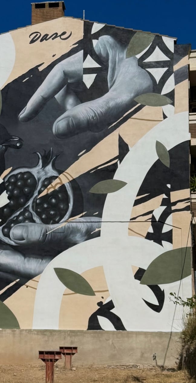 Mural de gran formato sobre fachada urbana realizado con aerosol. Representación figurativa que comb