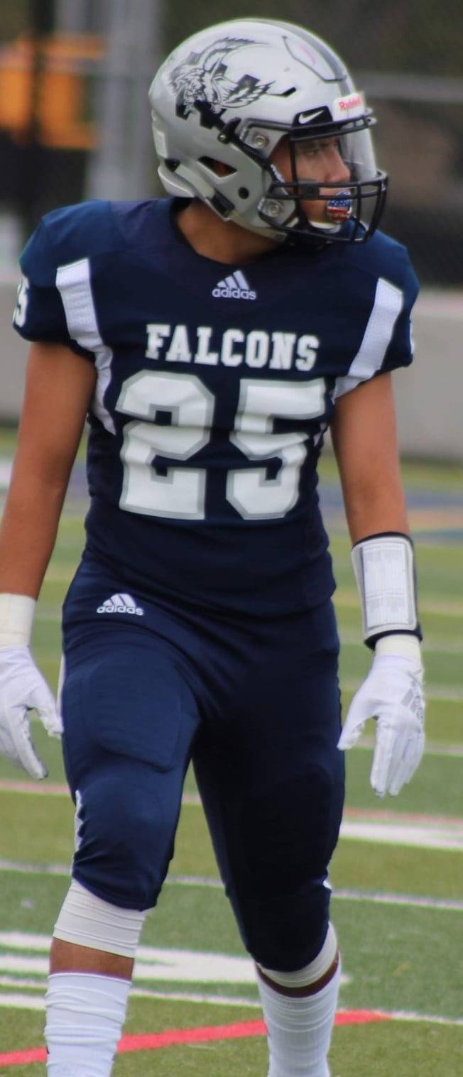 Picture of Isaac in a navy blue football jersey that reads "FALCONS" with the number 25.