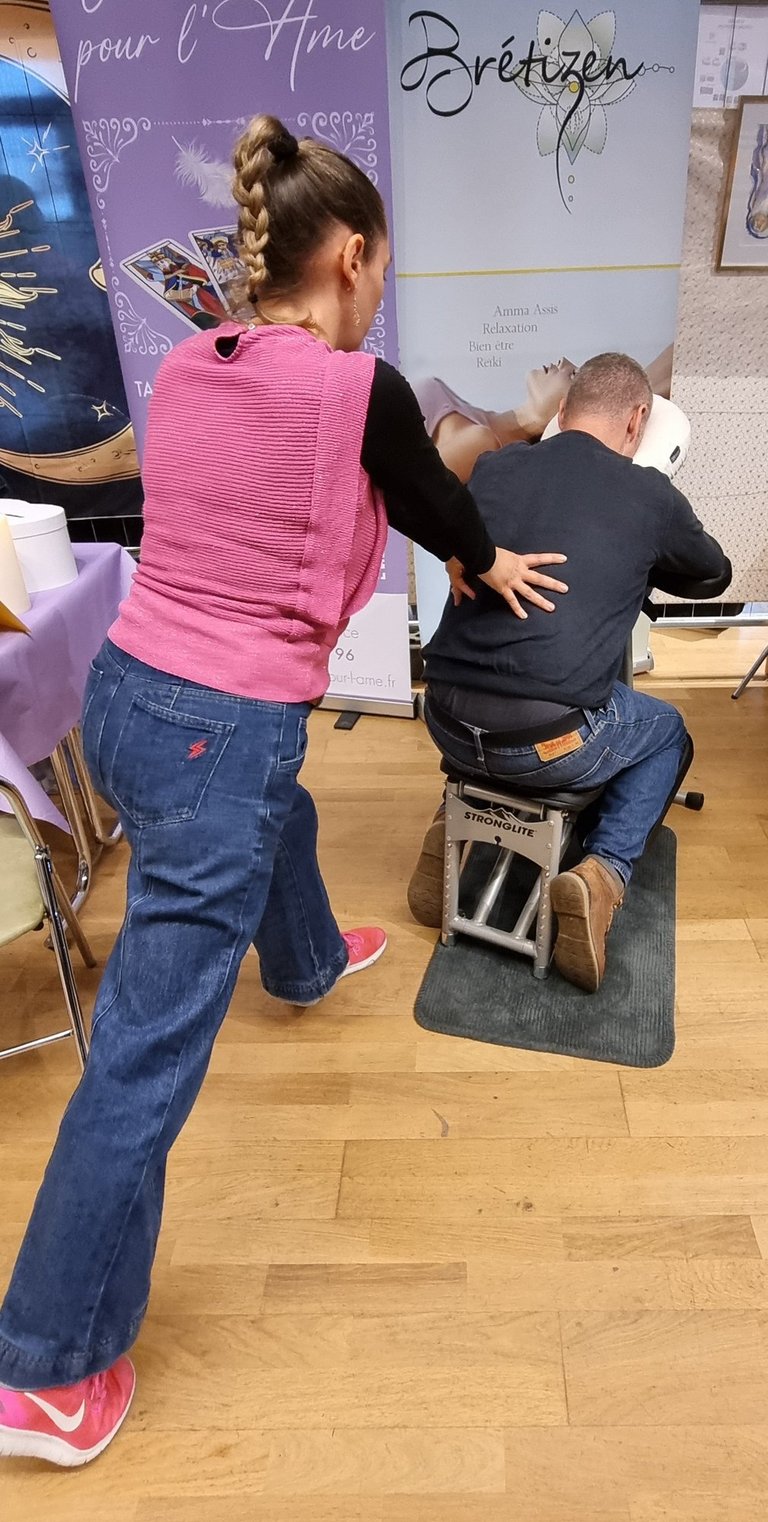 Massage Amma Assis réalisé par Marlène vu de dos lors d'un événementiel