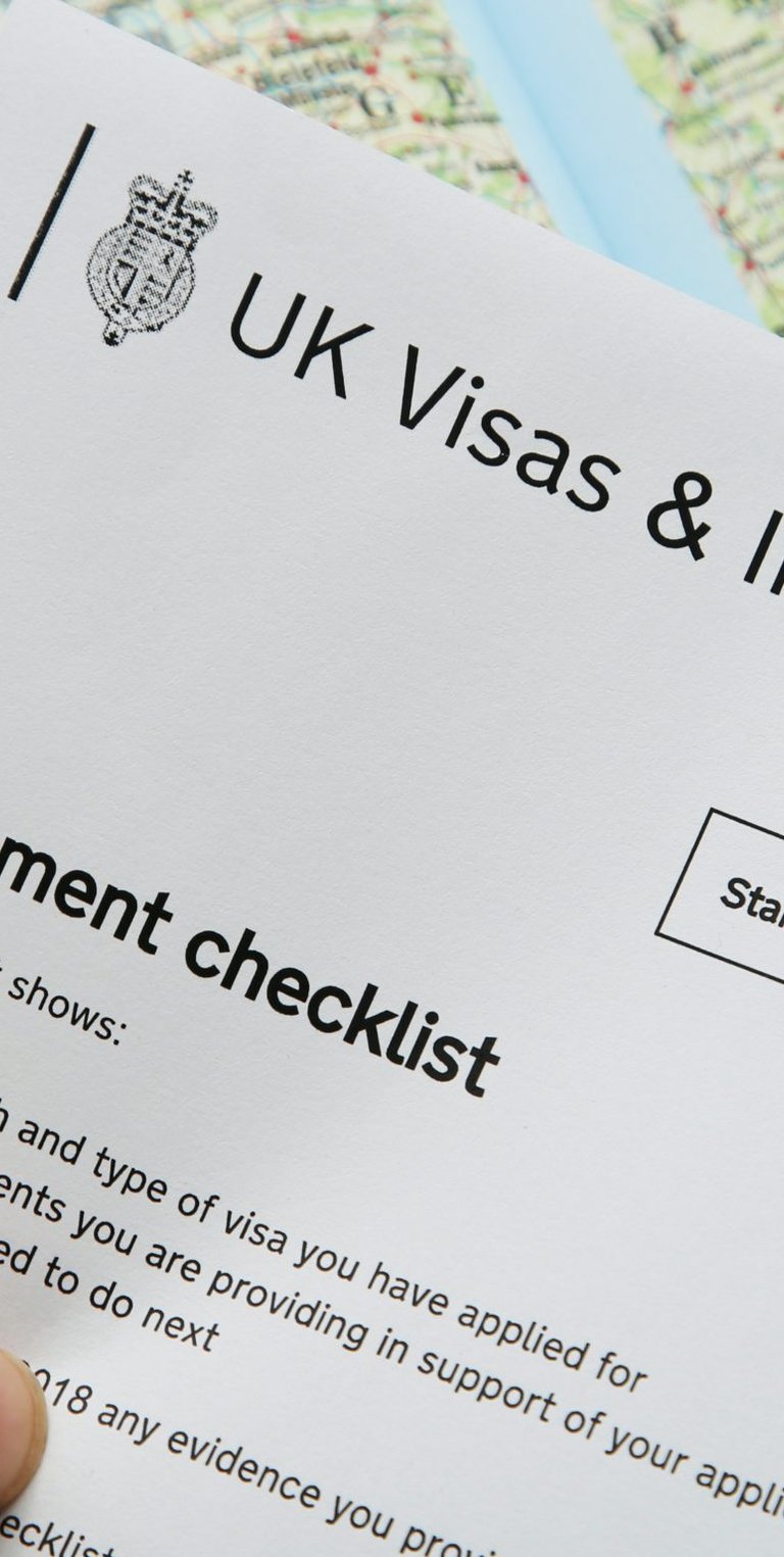 Person holding UKVI Document checklist in left hand