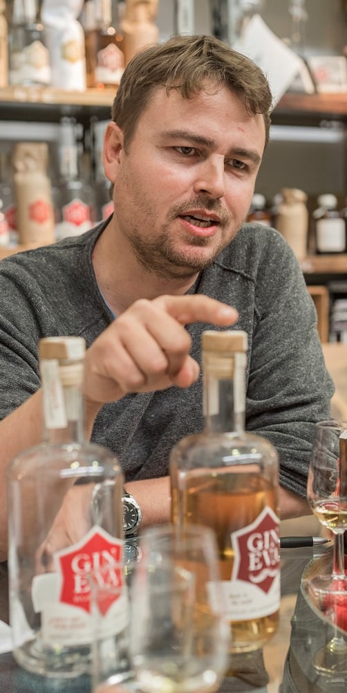 a man sitting at a table with bottles of alcohol