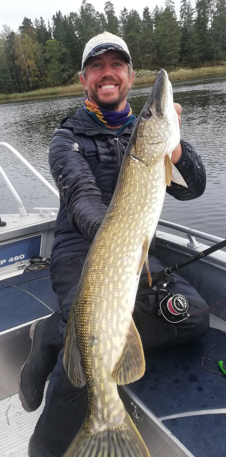 a man holding a pike in a boat 