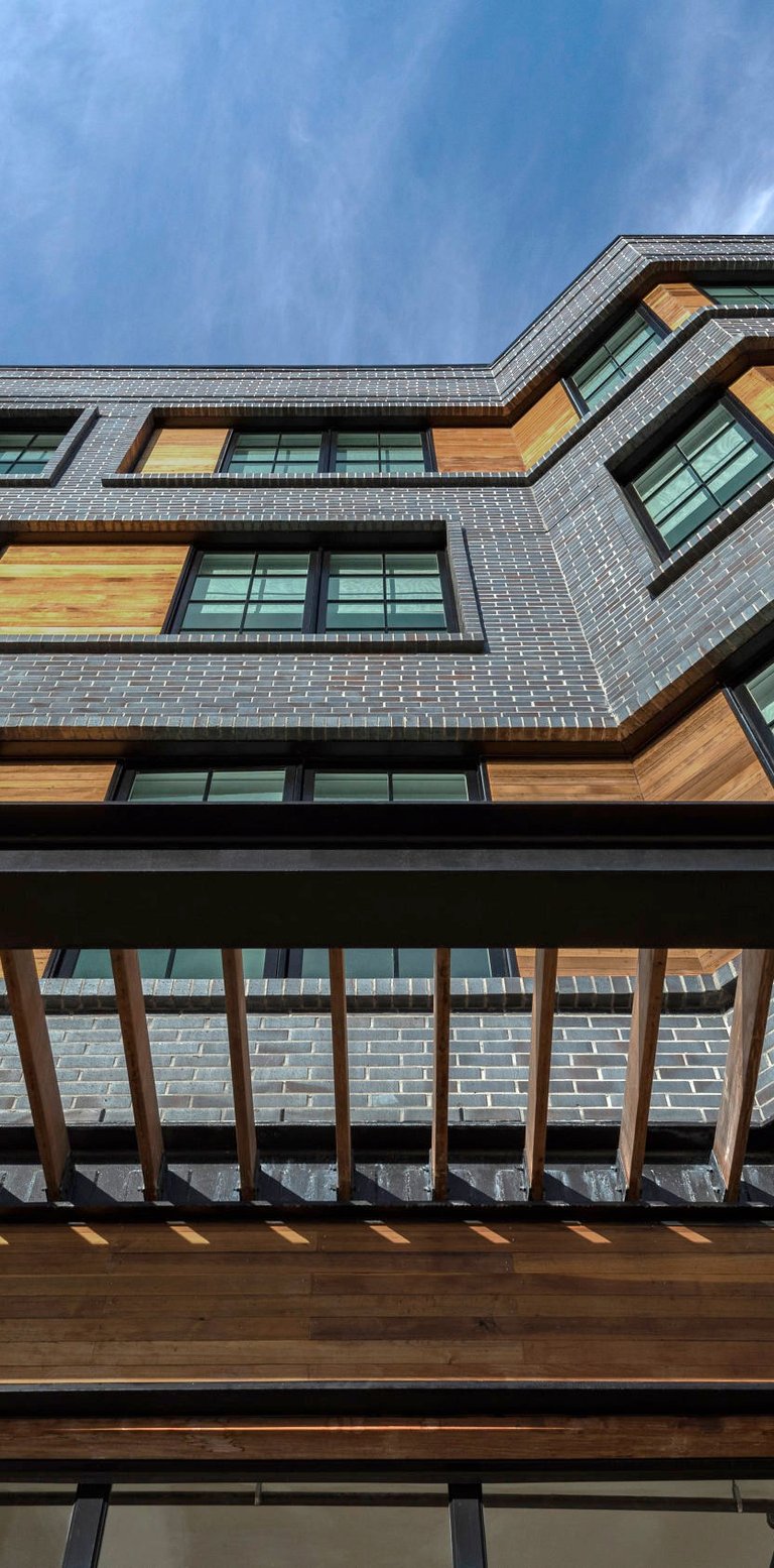 An architectural photograph of a grey brick apartment building
