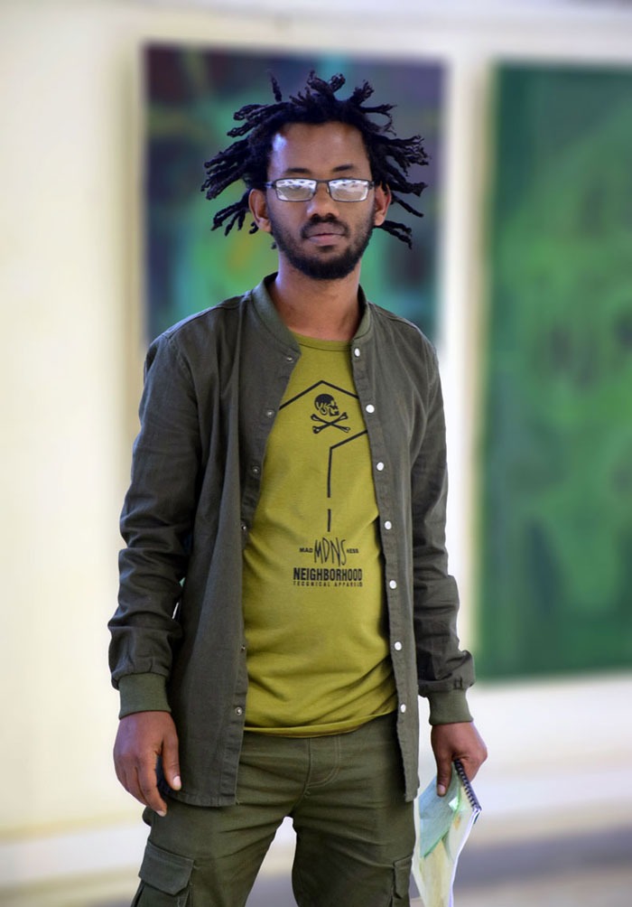 a man with dreadlocks and a green shirt