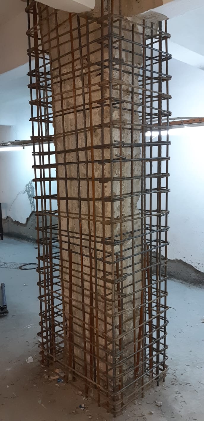 Bir yapının güçlendirme ve onarım aşamalarını gösteren fotoğraf.